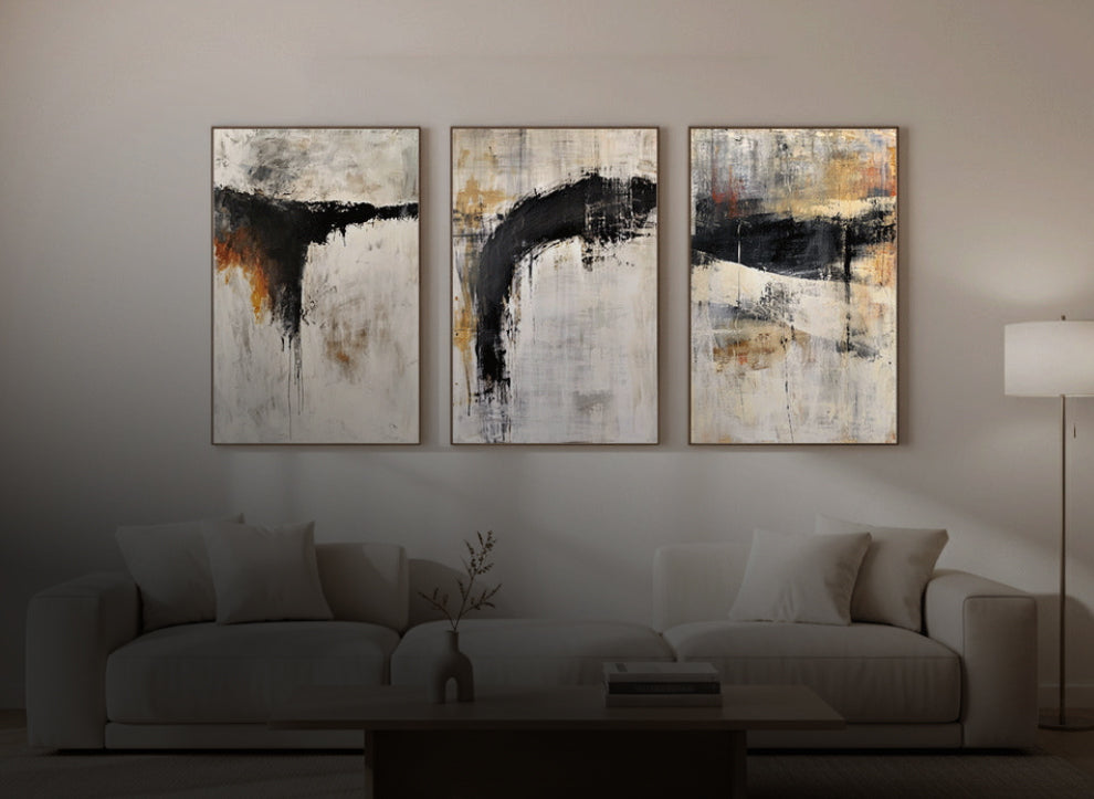 series of Three minimalistic neutral abstract art pieces on a wall above a sofa in a living room.